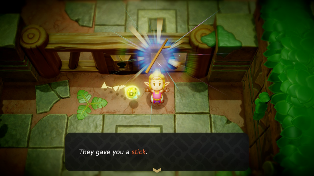 A sad girl holding a stick. The message "They gave you a stick" is shown at the bottom of the screen.[The game on display is Legend of Zelda: Echoes of Wisdom]