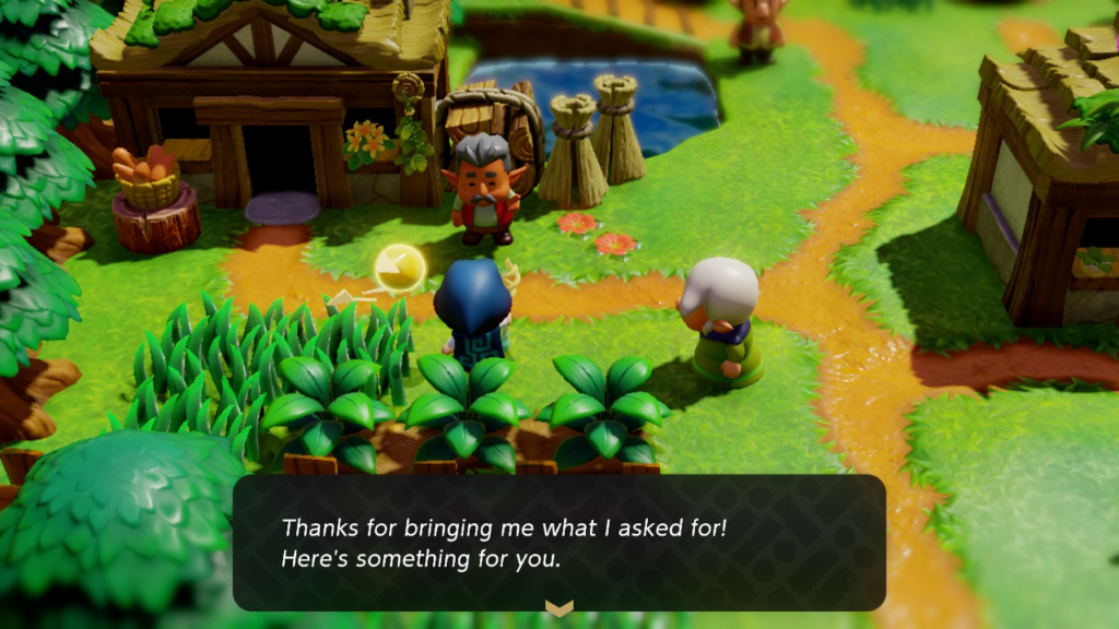 A hooded figure is being spoken to by two elderly folk. "Thanks for bringing me what I asked for! Here's something for you." is printed on the bottom of the screen. [The game on display is Legend of Zelda: Echoes of Wisdom]